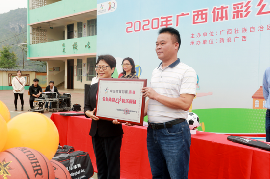 广西体育彩票管理中心党支部书记、主任李广为那标小学授牌