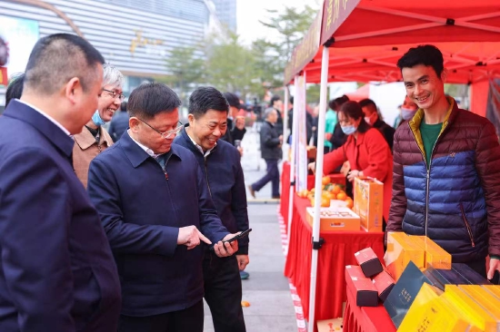 福建省农业农村厅领导在农产品展销区，看合格证与一品一码追溯信息