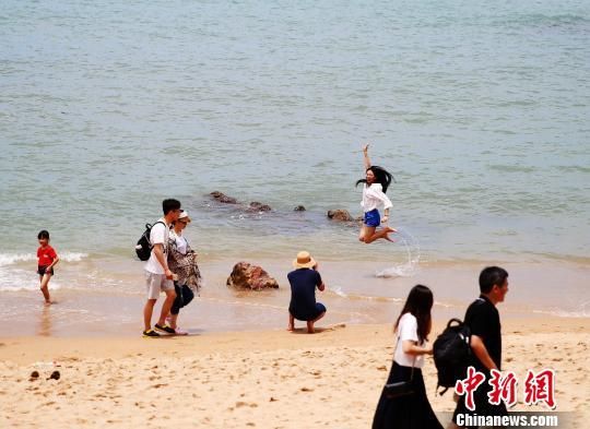 端午假期，游客在三亚海边嬉水。王晓斌 摄