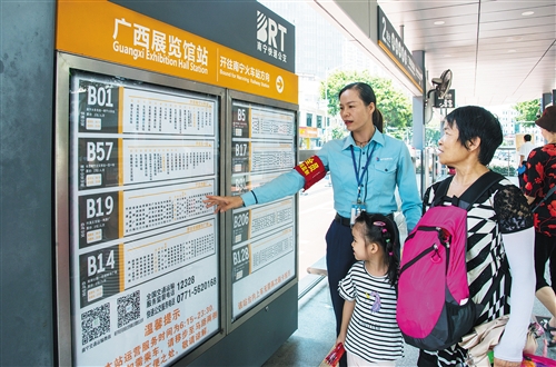 BRT 1号线站务人员耐心为乘客指引乘车线路。