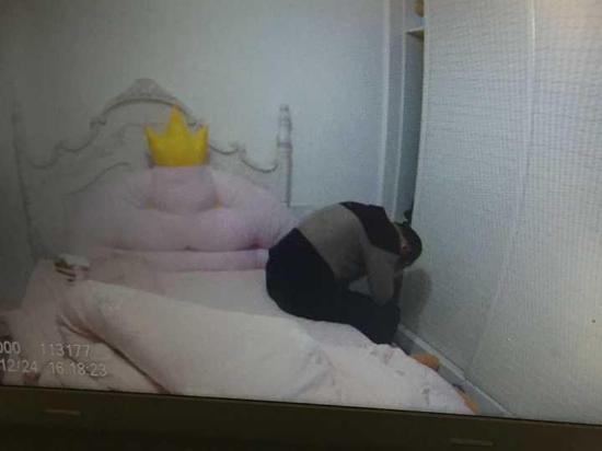 小王被民警发现后坐在床上