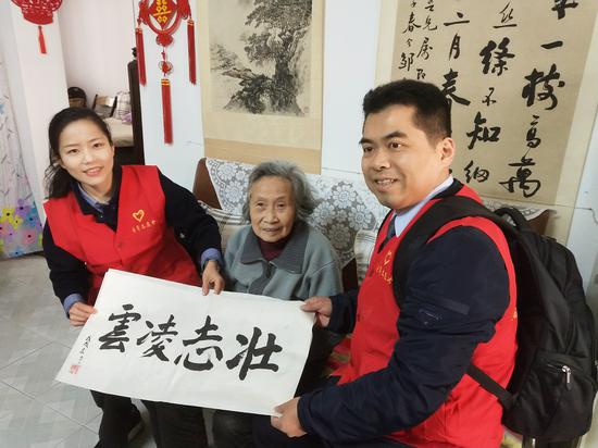 青年志愿者与缪亚梅老人合影