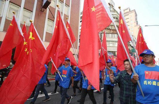 图为台湾民众手持五星红旗。(图:《中时电子报》)