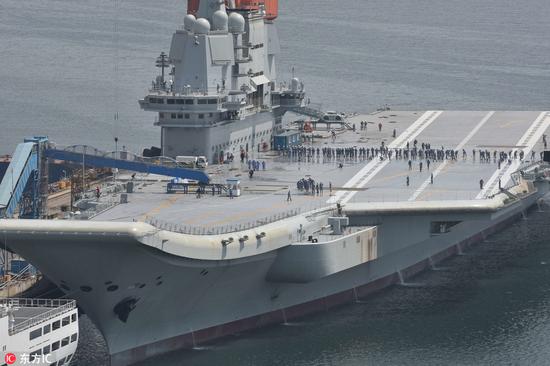 5月10日,舰员们在国产航母上排成一排,清理甲板(图片来源:东方ic)