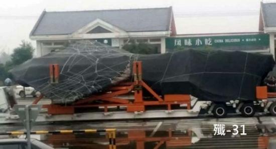 原文配图：华中某处的高速公路上，一架货车正运载一款神秘战机，外界估计是歼-31。（图片来源：香港《经济日报》网站）
