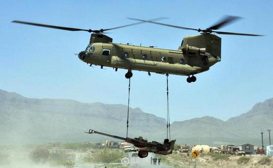 正在吊运轻型榴弹炮的CH-47直升机