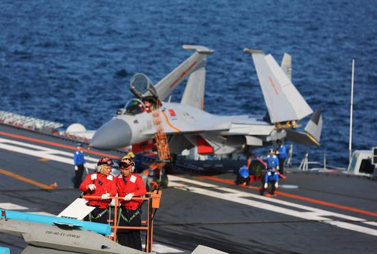 点击查看大图 战机进行弹药准备,红色衣服的工作人员是负责危险和安全管控