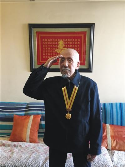 去年初,关爱抗战老兵组织为董老颁发纪念章,他起身敬礼致谢。受访者供图