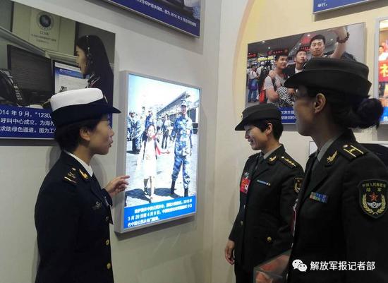 海军临沂舰观通部门报务班战士郭燕代表刚走到第九展区,就被几名代表拉到她自己的大幅照片前。记者吴敏摄