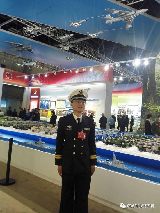 温国良与战车模型合影。记者吴敏摄