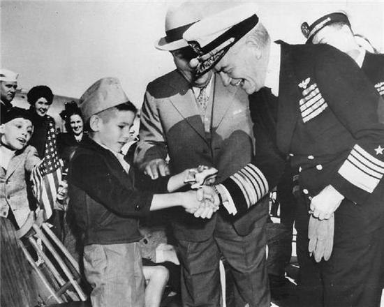 1945年战争结束后，哈尔西在美国的人气居高不下。图为他在新奥尔良港口和一个八岁男童握手。