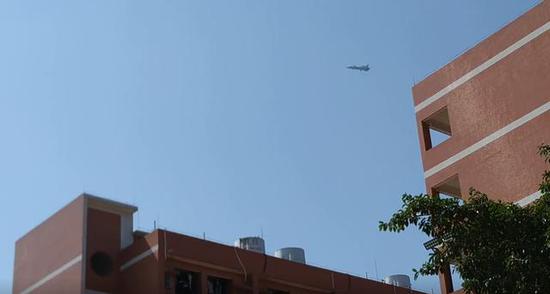 图为歼-20低空放下起落架飞临学校上空的瞬间。