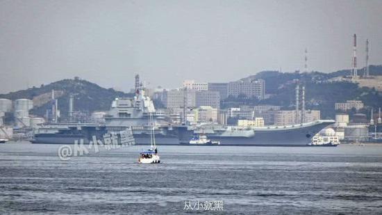 图为正在拖船的帮助下返港的国产航母,庞大的体型各位引人注目。