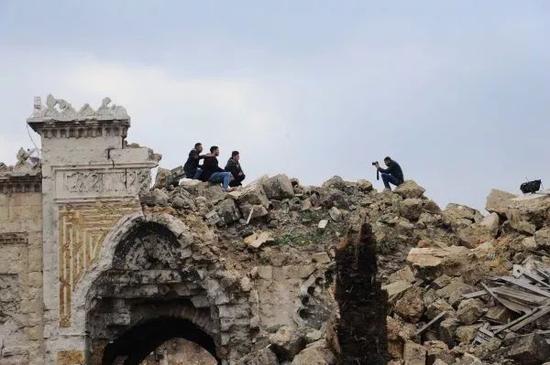 2017年12月17日,在叙利亚阿勒颇老城,几名市民在倭马亚清真寺的废墟上留影。