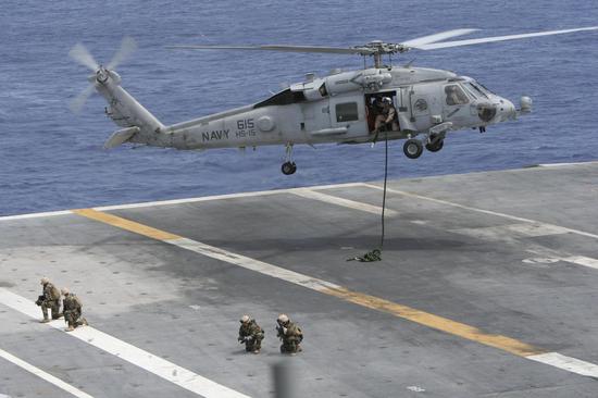 特种兵从“海鹰”SH-60舰载直升机上绳降至军舰甲板上。