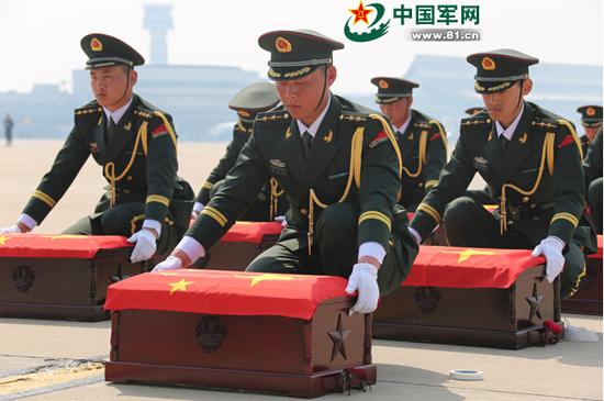 这支部队派出的全为军官的礼兵们小心放置棺木。