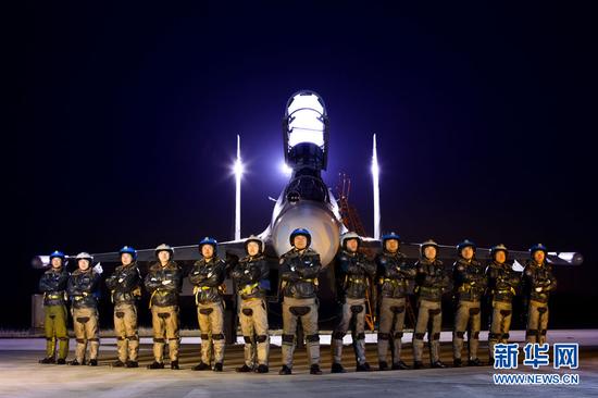 2015年3月4日,“海空雄鹰团”飞行员团队在夜训结束后在战机前合影。