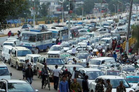 资料图：在尼泊尔加德满都一加油站，驾驶汽车的人们排队加油。