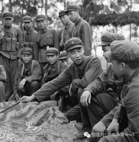 中越边境自卫反击战，战斗英雄李作成(中间拿指挥棒者)给战友们在沙盘上讲解战斗方案。1979年 叶用才摄