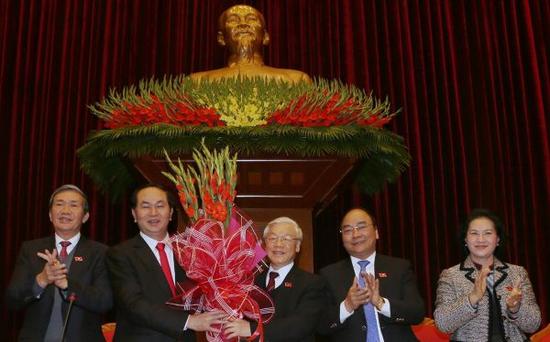 阮富仲(中)27日成功连任越共中央总书记后接受祝贺(法新社)