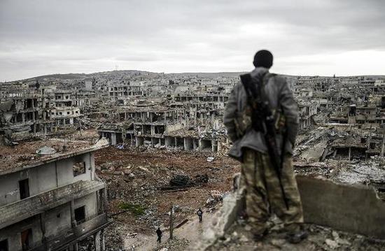 一名库尔德狙击手俯视已沦为废墟的科巴尼。