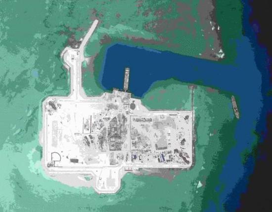 资料图：2015年3月16日华阳礁卫星图，美智库CSIS称该岛进出航道125米宽，加固海堤与多个支撑建筑完工，拥有3个混凝土工厂，2座直升机停机坪。