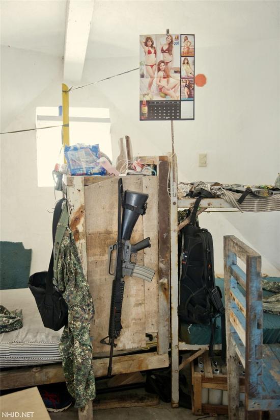 岛上菲律宾士兵宿舍的一角：步枪和成人日历放在一起
