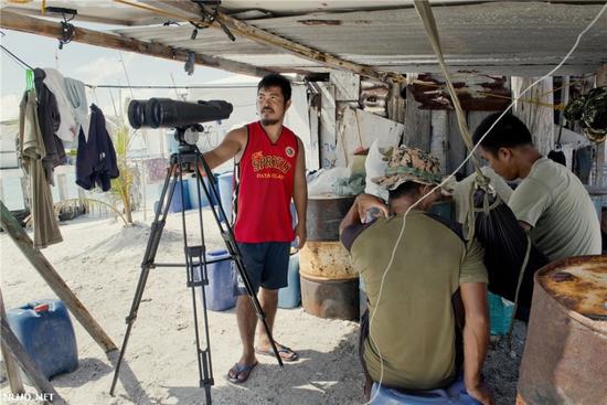 菲律宾士兵在用望远镜监视来往的船只