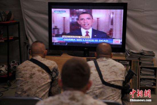 资料图：2011年5月1日，美国总统奥巴马发表全国电视演讲，宣布“基地”组织领导人奥萨马•本•拉登已被打死。图为驻阿美军某团士兵关注奥巴马演讲的电视新闻