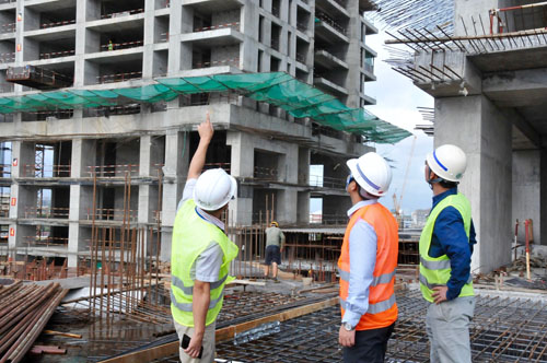 6月28日,在斯里兰卡科伦坡,中国港湾斯里兰卡区域公司总经理张晓强(中)在香格里拉二期、三期项目现场和同事交流。 新华社记者杨梅菊摄