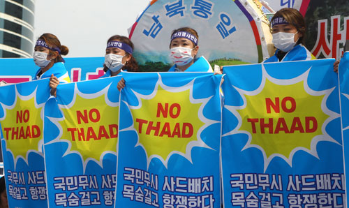 7月21日，在韩国首尔火车站广场，星州郡民众在集会上手持反对部署“萨德”系统的标语。新华社记者姚琪琳摄