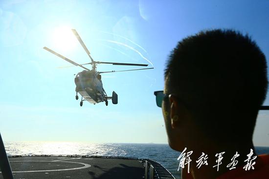 7月15日，海军卡-31预警直升机正在“崇明岛”舰上进行起降训练