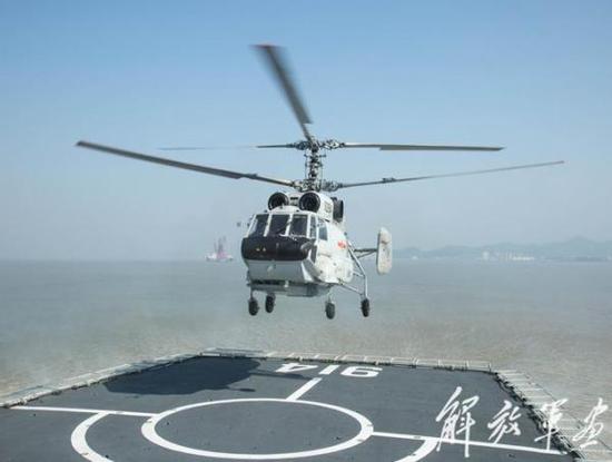 东海舰队航空兵直升机团的卡-31舰载预警直升机正在“武夷山”号登陆舰上进行训练