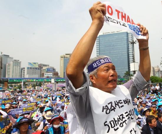 7月21日，在韩国首尔火车站广场，一名来自星州郡的男子在集会上高举反对部署“萨德”系统的标语