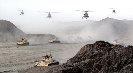 在实兵检验性演习中，新疆军区某步兵师合成战斗群实施空地联合打击（2013年10月18日摄）