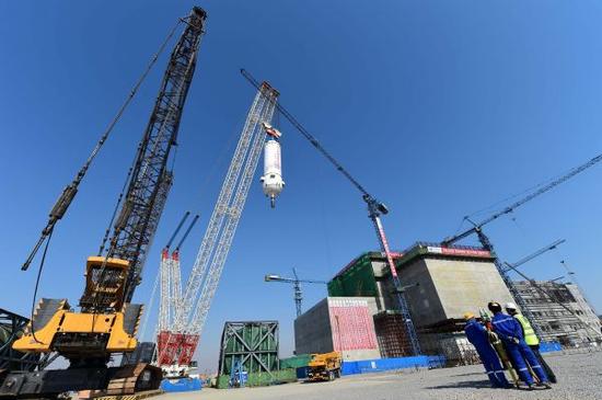 资料图片:3月20日,在华能山东石岛湾核电厂,反应堆压力容器在吊装中。新华社记者 郭绪雷摄