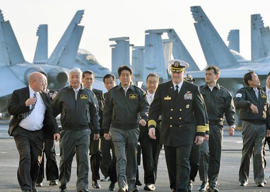 2015年10月18日，安倍访问神奈川县横须贺美军基地，登上“里根”号核动力航母