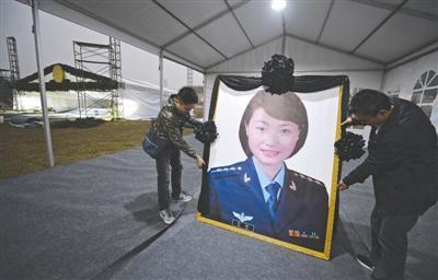 17日,崇州市体育中心,工作人员正在布置烈士余旭的遗像,余旭的公祭活动将在此举行。