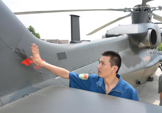 飞行员张浩能飞多种机型，这是2014年9月10日，在飞行前检查他的心爱战鹰。 肖庆明 摄