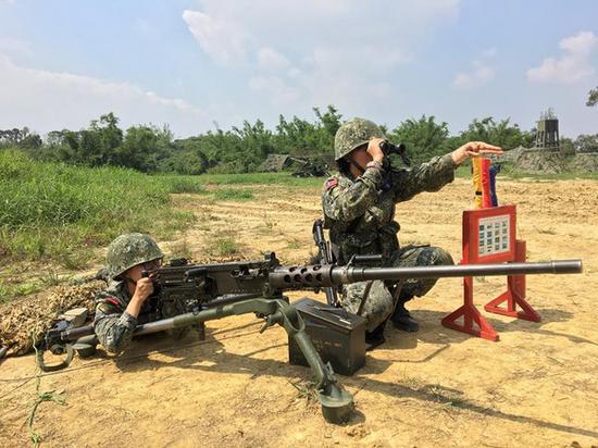 两名女性官兵操作50机枪的照片，遭网友炮轰姿势错误。（图片来源：台湾“东森新闻云”）