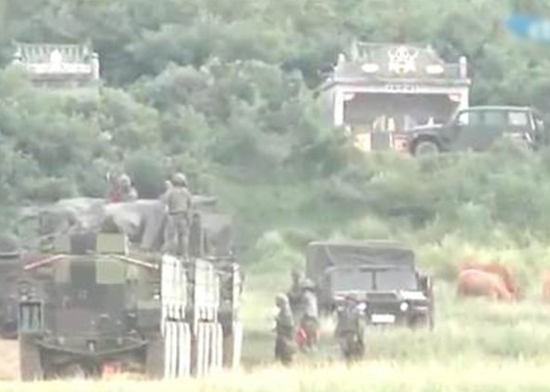 当地居民放出20多头黄牛进入基地吃草妨碍演练。(电视画面)