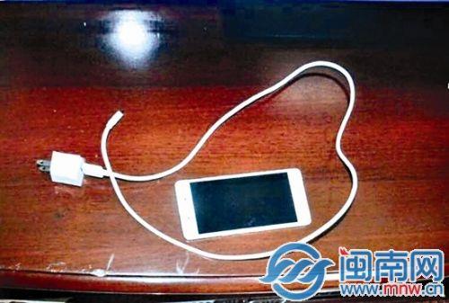 手机充电器被熏黑，连接手机充电接口的一端也部分凹陷，但手机仍能正常使用
