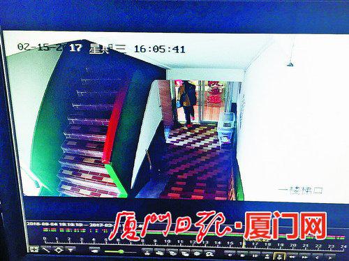 送餐员拿着包裹离开公寓楼。