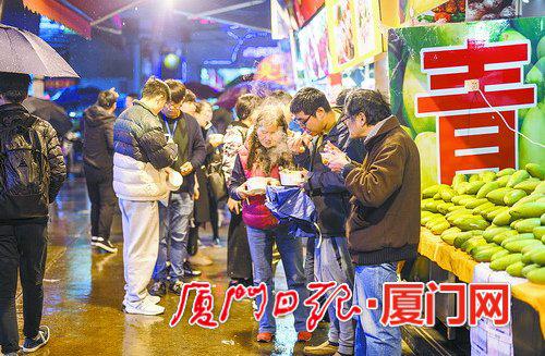 　　▲避雨时候，买份热腾腾的小吃暖暖身。（本报记者 林铭鸿 摄）