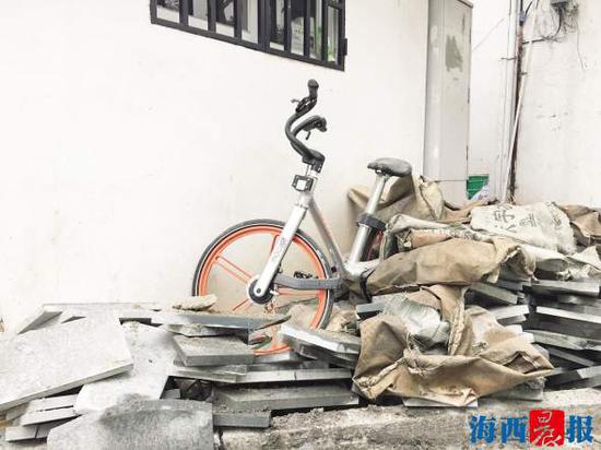 官任路上,一辆共享单车“可怜”地被掩埋在建筑材料中。