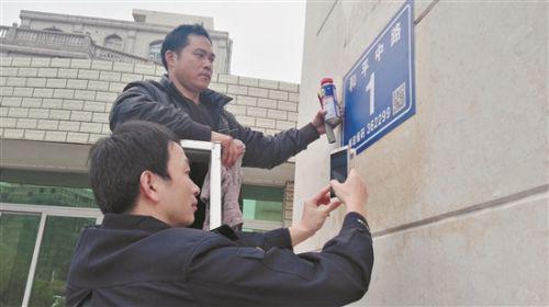 晋江市的公安民警在安装二维码门楼牌(蔡福仁 摄)