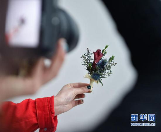 &nbsp;&nbsp;&nbsp; 3月16日，陈莹莹在帮助一名创业班学员拍摄课上制作的花艺作品。新华社记者 宋为伟 摄 