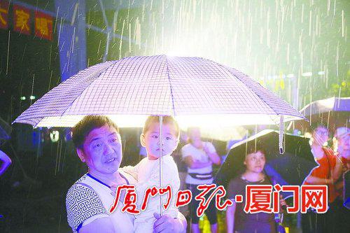 　　昨日有雨，图为雨中打伞的人们。 (本报记者姚凡摄)