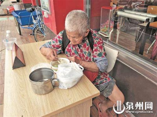 流浪阿婆正吃着高中生为她买来的饭