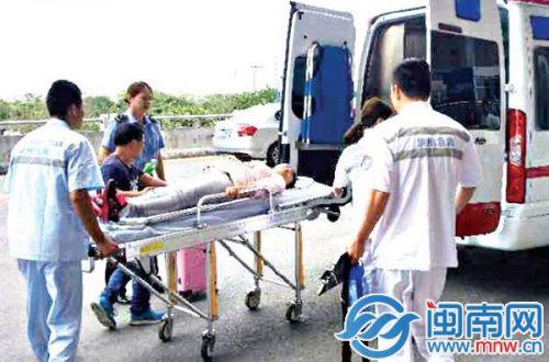 救护人员将孕妇抬上担架,送上救护车
